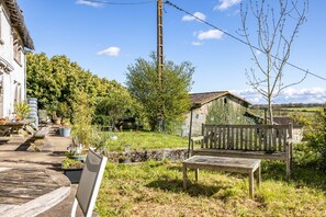 A rustic outdoor setting with a wooden bench, a stone wall, and a small wooden structure. - Bed and Breakfast 'Chambre Klimt' with Shared Pool, Shared Terrace and Wi-Fi (Sanxay)