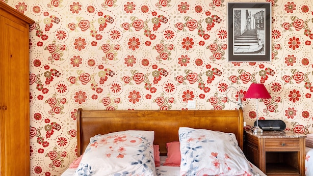 A bedroom with a floral wallpaper, a wooden headboard, a bedside table with a lamp, and a framed picture on the wall. - Bed and Breakfast 'Chambre Klimt' with Shared Pool, Shared Terrace and Wi-Fi (Sanxay)