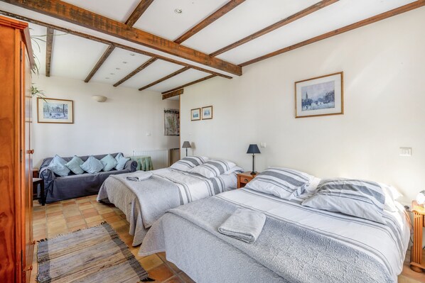 A room with two beds, a sofa, a wooden ceiling, and a framed picture on the wall. - Bed and Breakfast 'Chambre Pissaro' with Shared Pool, Private Terrace and Wi-Fi (Sanxay)