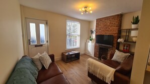 A living room with a fireplace, two sofas, a coffee table, and a TV. - City Centre, River views, Sleeps 5, Free Parking (Canterbury)