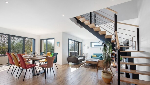A modern interior with a dining area, a staircase, and a living room. - Newly Built House for Rent! (Plouescat)