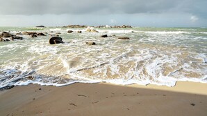 A beach with waves, rocks, and a cloudy sky. - Newly Built House for Rent! (Plouescat)