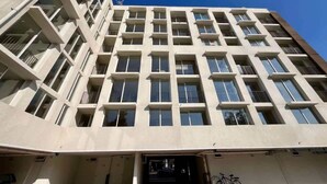 A modern multi-story building with a grid of windows and balconies. - Urbano Art Stico Irarr Zaval A C Laundry Parking (Santiago)