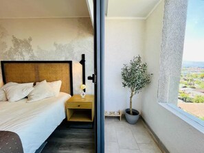 Ein Hotelzimmer mit Bett, Nachttisch und einer Zimmerpflanze.