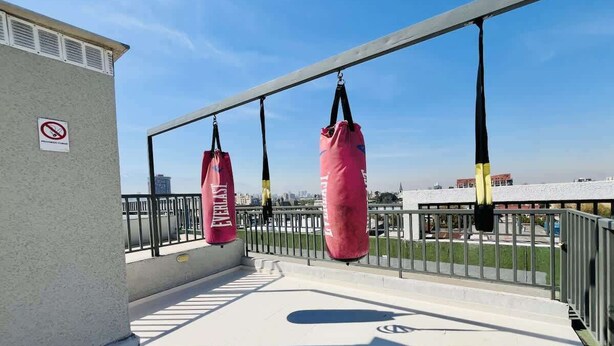 Eine Dachterrasse mit zwei rosafarbenen Sandsäcken und einem Rauchverbot-Schild.