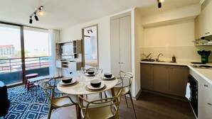 Eine moderne Küche mit Essbereich, großen Fenstern und Blick auf die Stadt.