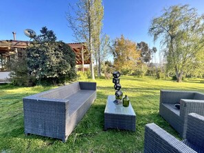 An outdoor seating area with wicker furniture and a decorative sculpture. - Casa Foresta BBQ Parking Pet Swimming Pool Wifi (Melipilla)