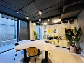 Una sala conferenze moderna con un ampio tavolo, sedie e una parete vetrata che offre vista sull'esterno.