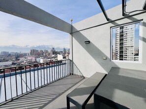 En balkon med udsigt over bybilledet og fjerne bjerge.