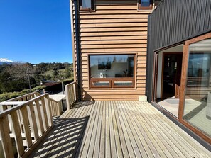 Een houten terras met uitzicht op een bergachtig landschap.