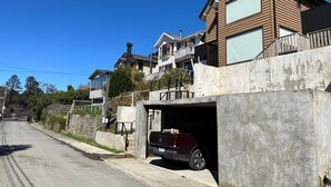 A residential area with houses, a driveway, and a parked vehicle. - Casa Playa Hermosa BBQ Jacuzzi Parking Wifi (Puerto Varas)