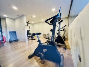 Kuntosali, jossa on erilaisia kuntoilulaitteita, kuten kuntopyörä ja crosstrainer.