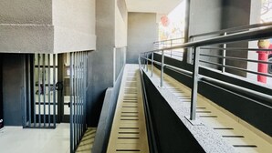 A modern interior with a staircase, metal railings, and a view of the outside. - Urbano Esperanza Plaza Yungay Laundry Pet Pool (Santiago)