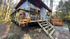 A cabin with a wooden deck and stairs leading to a loft-style bedroom with a window. - Caba a Roble BBQ Home Office Washer Wood Hot Tub (Loncoche)