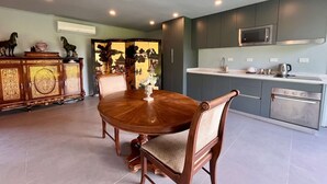 A modern kitchen with grey cabinets, a stainless steel microwave, and a white countertop. - Casa Melipill n BBQ Jacuzzi Mini-pool Pet Wifi (Melipilla)