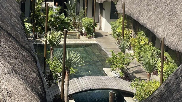 A resort with thatched-roof structures, a pool, and lush greenery. - Résidences les Alizées (Grand-Baie)