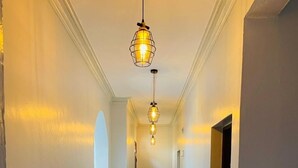 A hallway with three pendant lights, white walls, and a tiled floor. - Nyali Luxe 2BR • Beach - Parking - Peaceful, Safe (Mombasa)