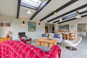 Un salon moderne comprenant un canapé, une table basse et un coin repas avec des chaises et une table.
