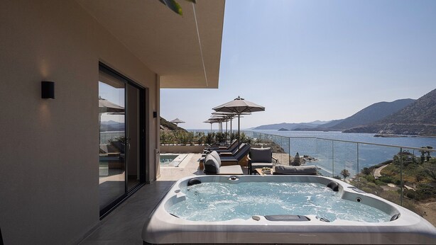 A modern outdoor hot tub with a view of a lake and mountains. - Celeste Bali Suites (Mylopotamos)
