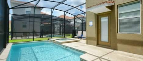 Una piscina con zona cubierta, una puerta y una ventana con persianas.