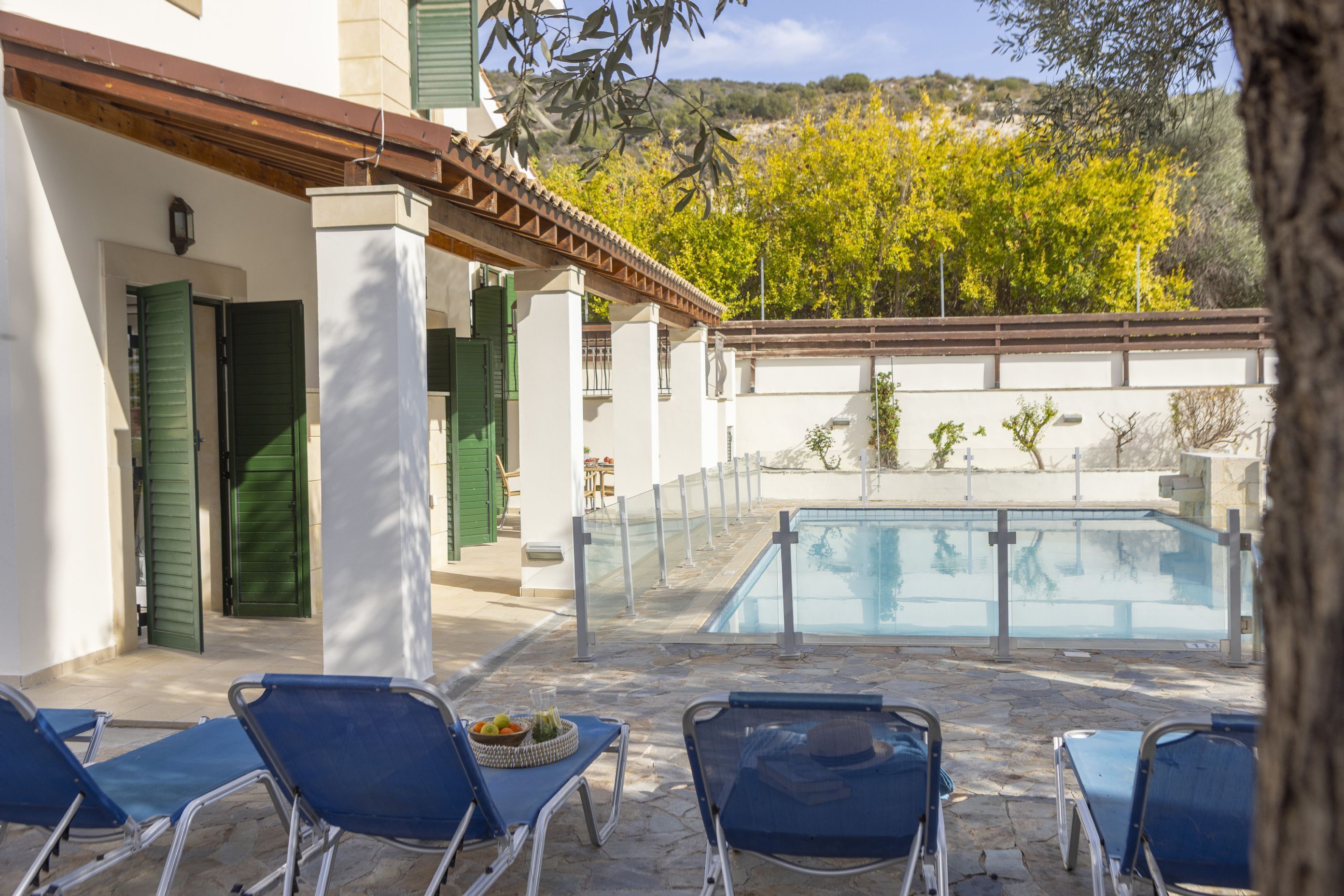 Zona de piscina con sillones de descanso y una piscina pequeña.