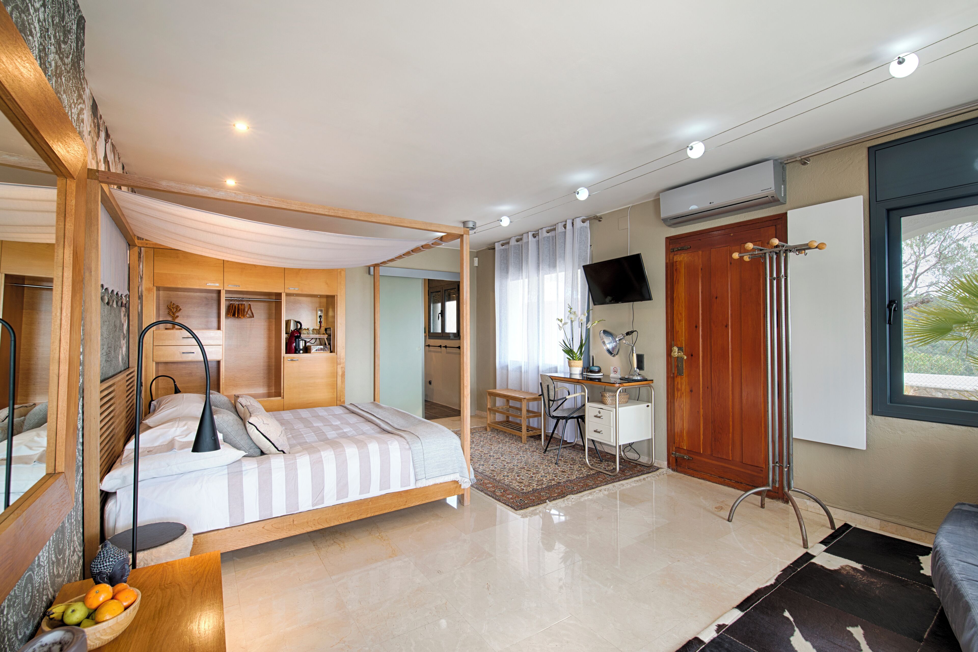 Un dormitorio moderno con cama, escritorio y televisor.