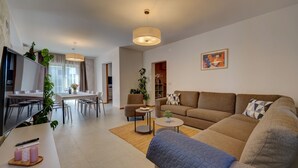 En moderne stue med sofa, sofabord og spiseområde.