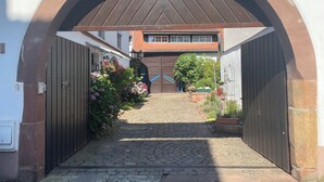 A cobblestone pathway leading to a gated entrance with a metal archway. - Large, comfortable half-timbered house with courtyard in the heart of Wissembourg (Wissembourg)