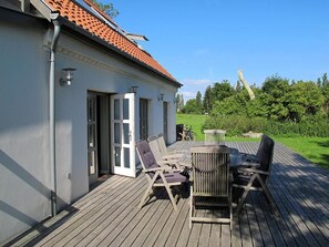 A wooden deck with outdoor seating, a small table, and a trash can. - Vejrø Resort (Vejrø)