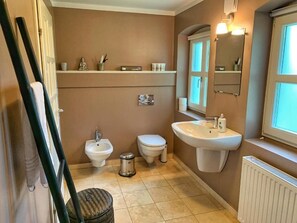 A bathroom with a bidet, toilet, sink, and a mirror. - Vejrø Resort (Vejrø)