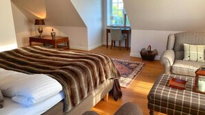 Ein Schlafzimmer mit Bett, Stuhl, Schreibtisch und Fenster.
