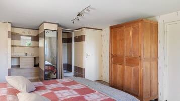 Un dormitorio con cama, armario, baño y ropero.