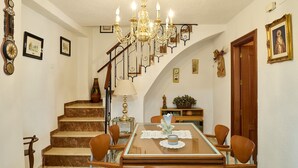 A dining area with a chandelier, a staircase, and a wooden door. - Country House 'Romo 2' with Mountain View, Wi-Fi and Air Conditioning (Rute)