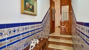 A staircase with blue and white patterned tiles, a wooden door, and a small table with a Dalmatian figurine. - Country House 'Romo 2' with Mountain View, Wi-Fi and Air Conditioning (Rute)