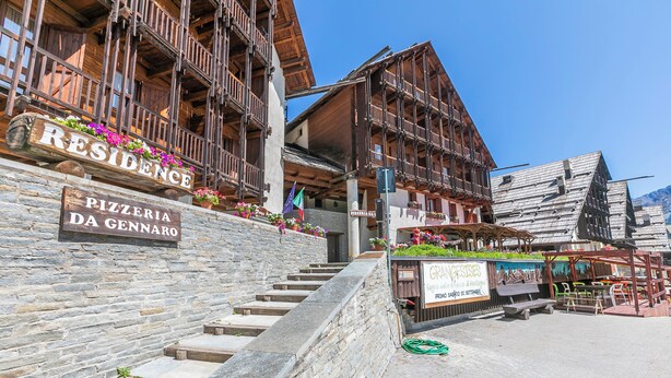 A wooden building with a stone wall and a sign for 'Pizzeria da Gennero.' - Grange Studio (Sauze di Cesana)