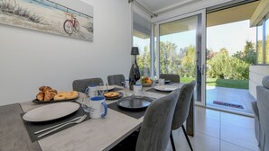 Ein Essbereich mit einem Tisch, der für das Frühstück gedeckt ist, darunter Croissants und eine Obstschale.