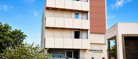 A modern building with a sign reading 'Nirmalya Guest House.'