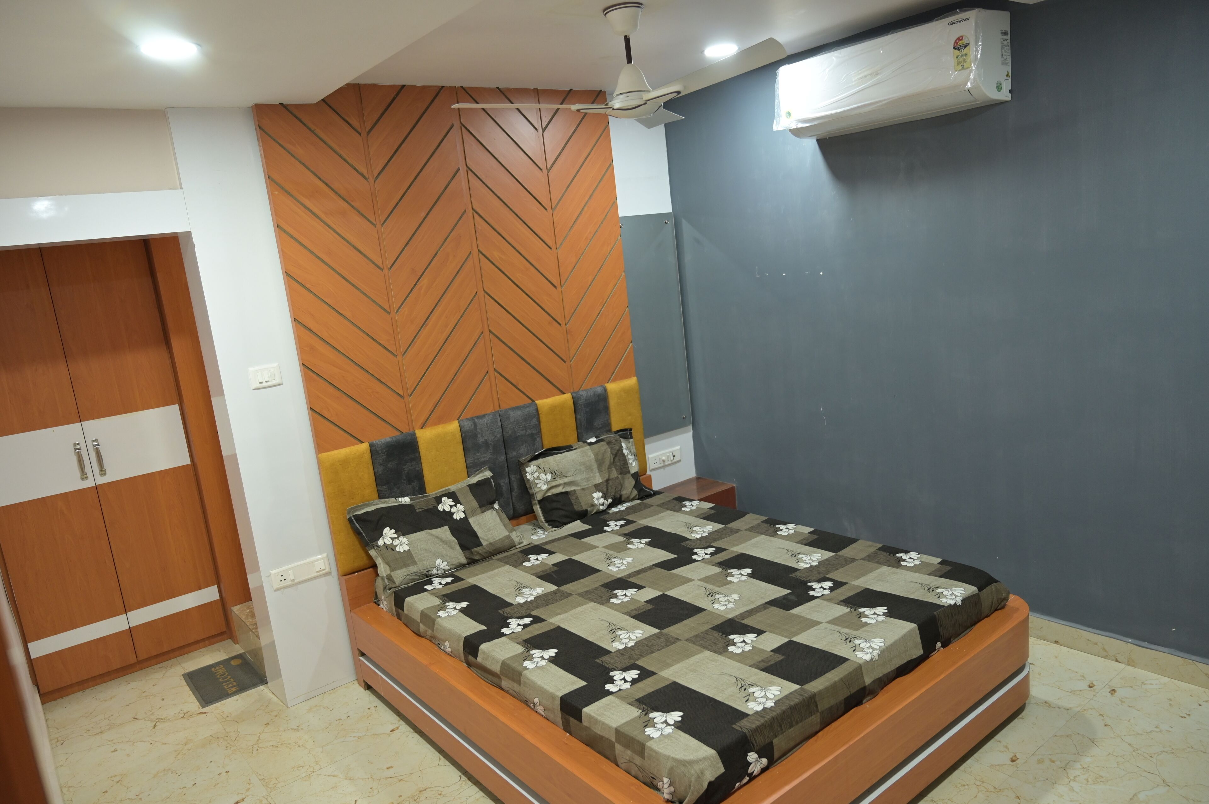 A bedroom with a bed, wardrobe, and a ceiling fan.