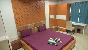 A bedroom with a bed, a desk, a wardrobe, and a chair. - Nirmalya Guest House (Brahmapur)