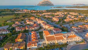 A coastal town with a prominent mountain in the background. - A welcoming space, ideal for two people (with the option of adding an infant), perfect for those seeking comfort and practicality. The bedroom offers a double bed—or comfortable single beds, depending on your needs—along with a small table and chairs (Porto San Paolo)