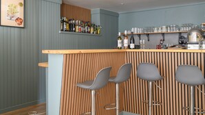 A bar area with a wooden counter, three grey bar stools, and shelves with bottles and glasses. - Guest Room 5 with Shared Pool, Garden, and Wi-Fi (Betton-Bettonet)
