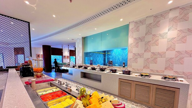 A buffet area with various food items and a person in the background. - The Corbett Hideaway - By Leisure Hotels (Ramnagar)