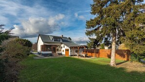A modern house with a sloped roof, a covered patio, and a well-maintained lawn. - Spacious Renovated House in Wolfsthal, Austria - Perfect for Families and Groups (Wolfsthal)