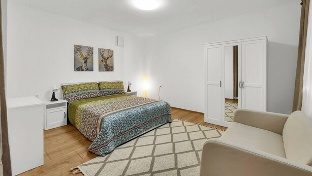 A bedroom with a bed, nightstands, a dresser, a wardrobe, and a sofa. - Spacious Renovated House in Wolfsthal, Austria - Perfect for Families and Groups (Wolfsthal)