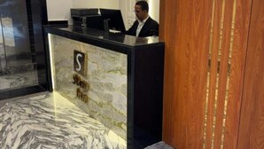 A reception desk with a marble design, a wooden panel, and a sign with the letter 'S'. - Comfortable Twin Room at Stay Inn 51 Hotel (Banī Ghālib)