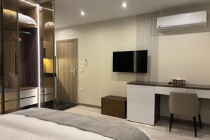 A modern hotel room with a bed, a desk, a TV, and a wardrobe. - Stay Inn 51 Hotel – Cozy Family Rooms for Your Perfect Getaway (Banī Ghālib)