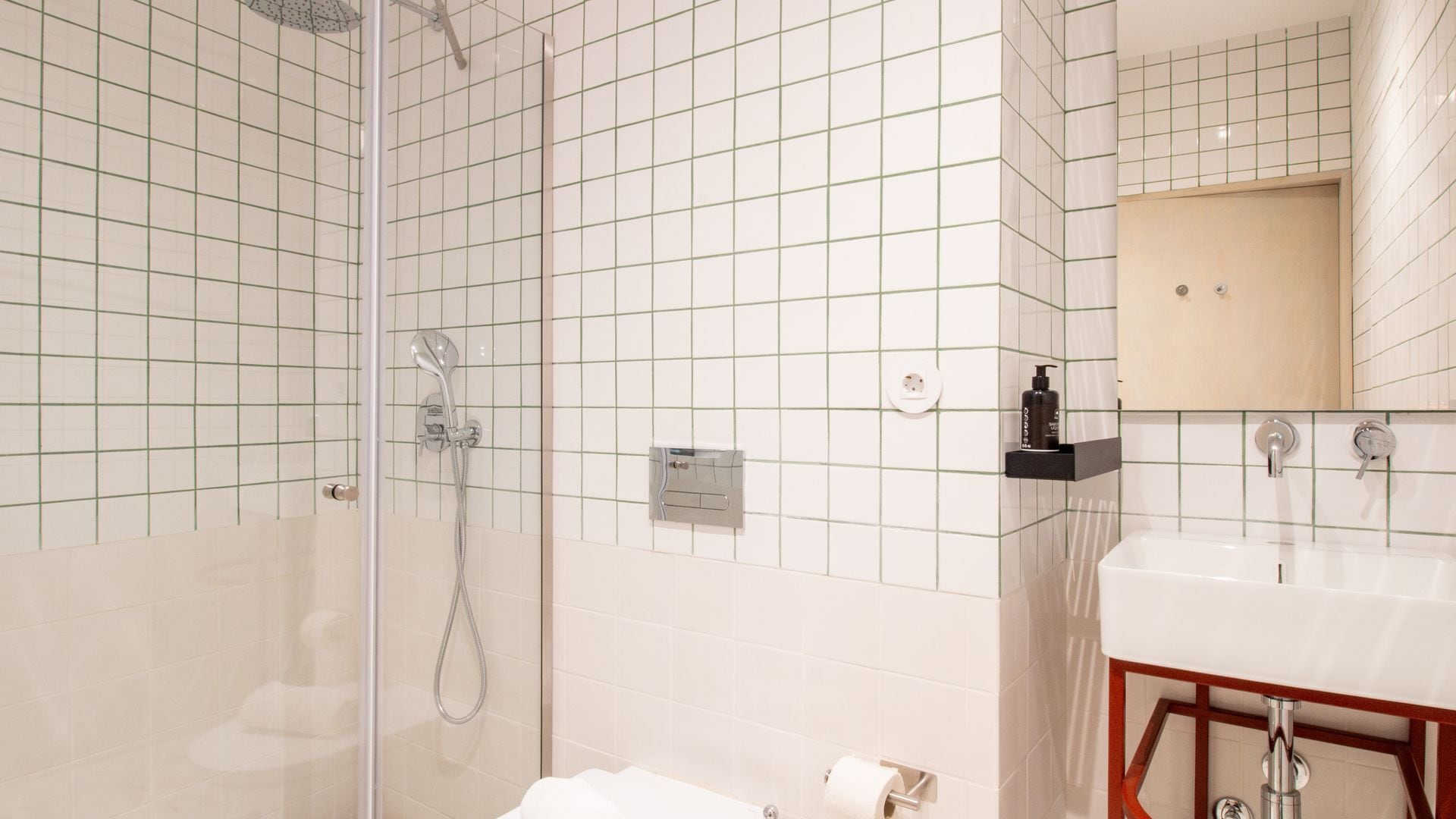 Baño con ducha, lavamanos y espejo.