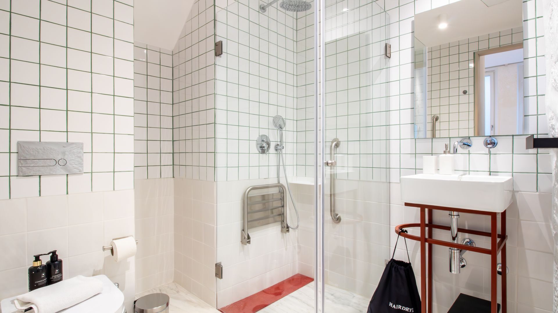 Een moderne badkamer met een douchecabine van glas, een wit wastafelmeubel met houten details, en een spiegel boven de wastafel.