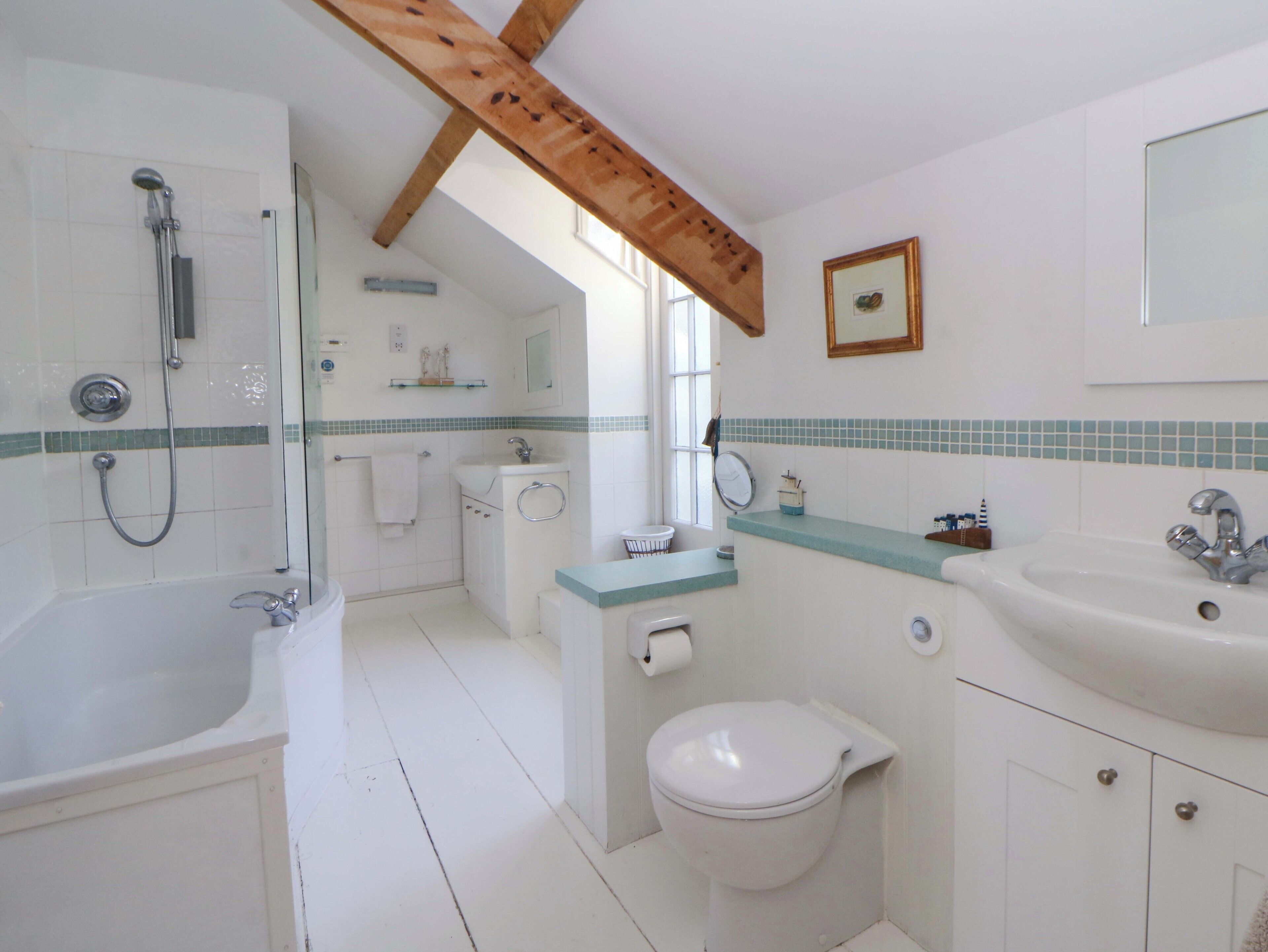 Une salle de bain équipée d’une baignoire, de toilettes, d’un lavabo et d’une douche.