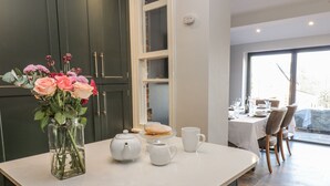 A kitchen counter with a vase of flowers, a teapot, and a plate of food. - 26 Frenchgate (Richmond)